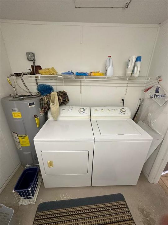 Full size washer and dryer located in their own separate room just inside the garage