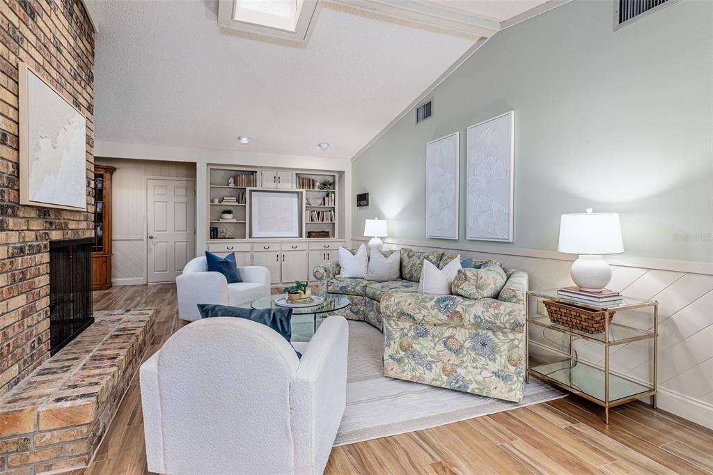 Family room with vaulted ceilings, skylight, and built-in cabinetry