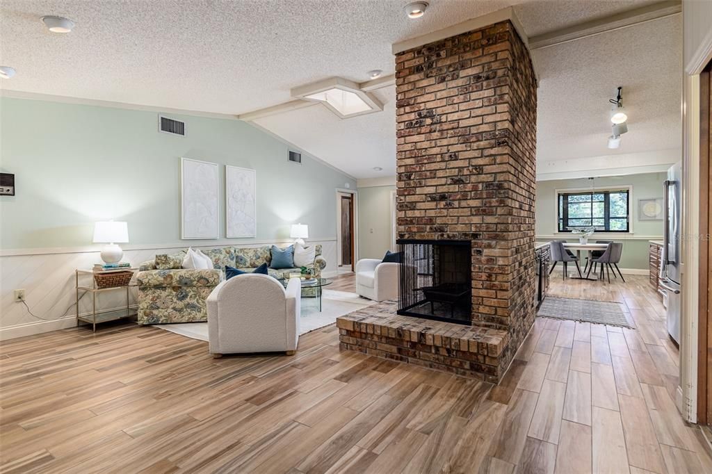 Floor to ceiling wood burning fireplace merging the family room and kitchen
