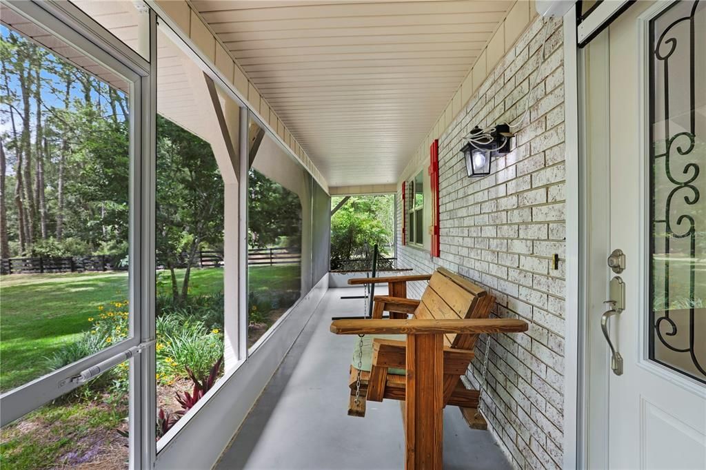 Screened in front porch with an amazing view of the property out front