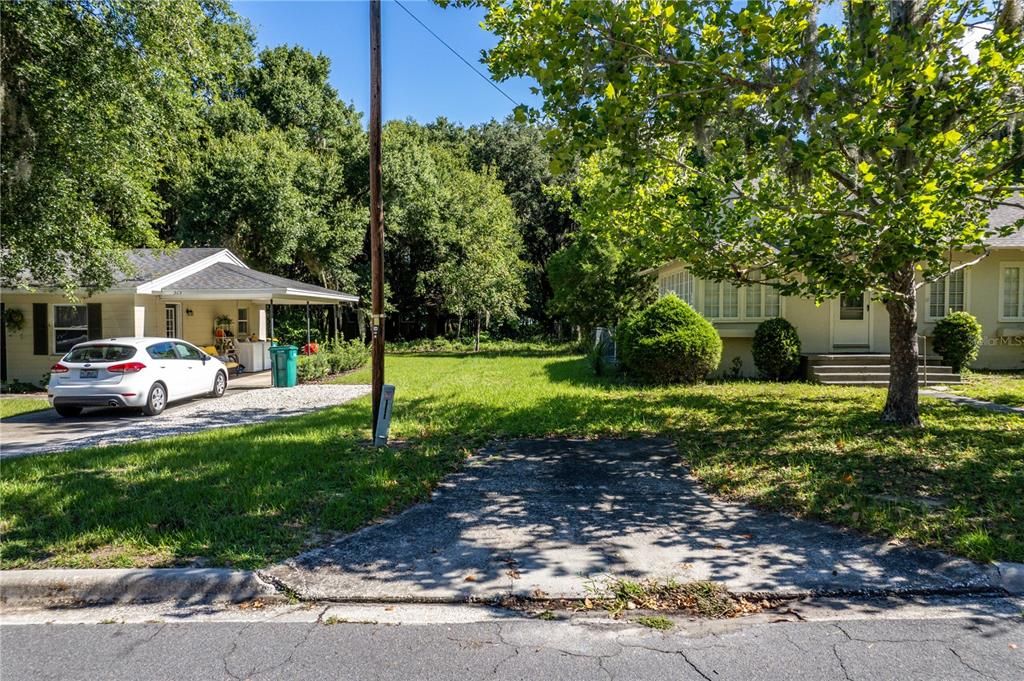 Concrete driveway apron leads straight back to lot