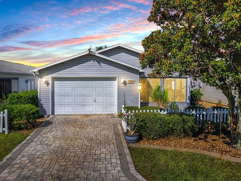 Paver driveway with mature landscaping