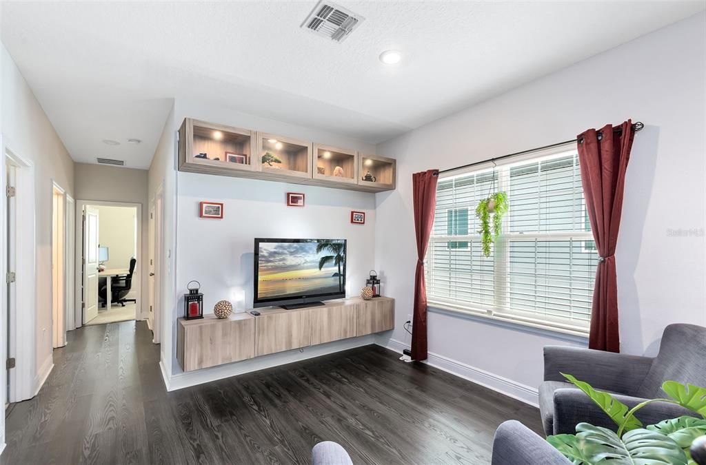 A cozy loft space awaits, complete with stylish built-in shelves and glass enclosed cabinets, perfect for showcasing your treasures.