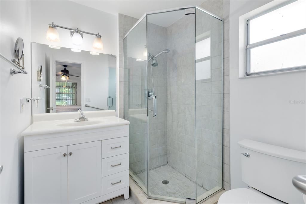 The primary bath is modern with a single vanity and shower.