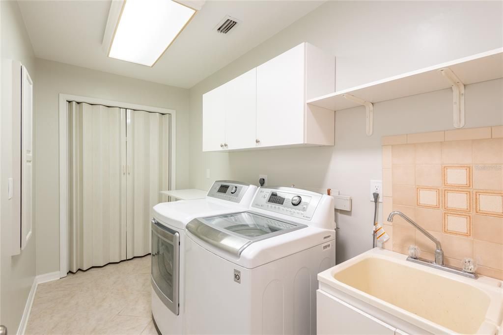 Laundry room with built in ironing board , folding table and laundry sink.