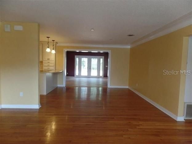 Open view from the living room through the dining room and family room to the patio doors.