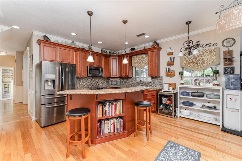 The heart of the home is the newly remodeled kitchen, a chef's dream with granite countertops, pendant lighting, stainless steel appliances, and rich cherry cabinets.