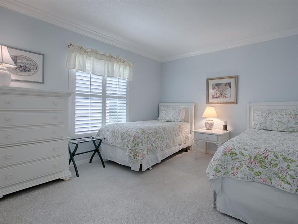 2ND GUEST ROOM WITH CARPET, CROWN MOLDING, AND PLANTATION SHUTTERS.