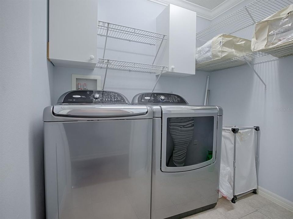 LAUNDRY ROOM IS IN THE HALLWAY TO THE PRIMARY BEDROOM AND WASHER AND DRYER DO CONVEY WITH THE HOME. THERE IS ANOTHER LINEN CLOSET IN THE HALLWAY.