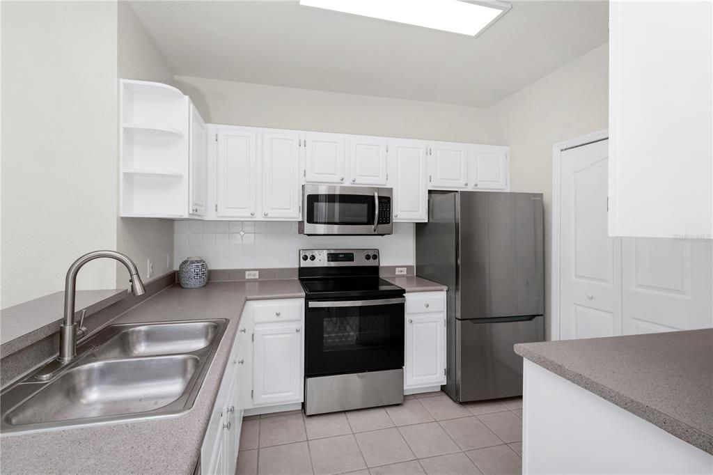 Kitchen shows BAR.Door is to laundry (kitchen is gray w/ stainless steel appliances