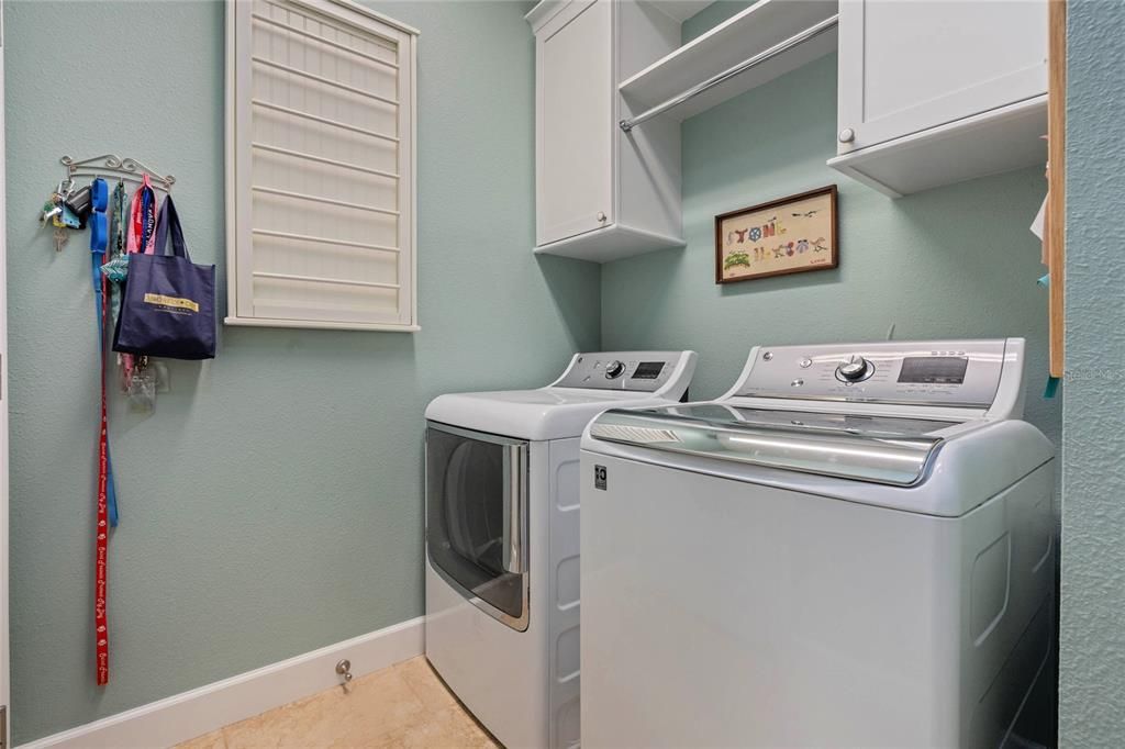 Laundry Room is enhance with a Solar Sky Light, Washer, Dryer and Cabinetry