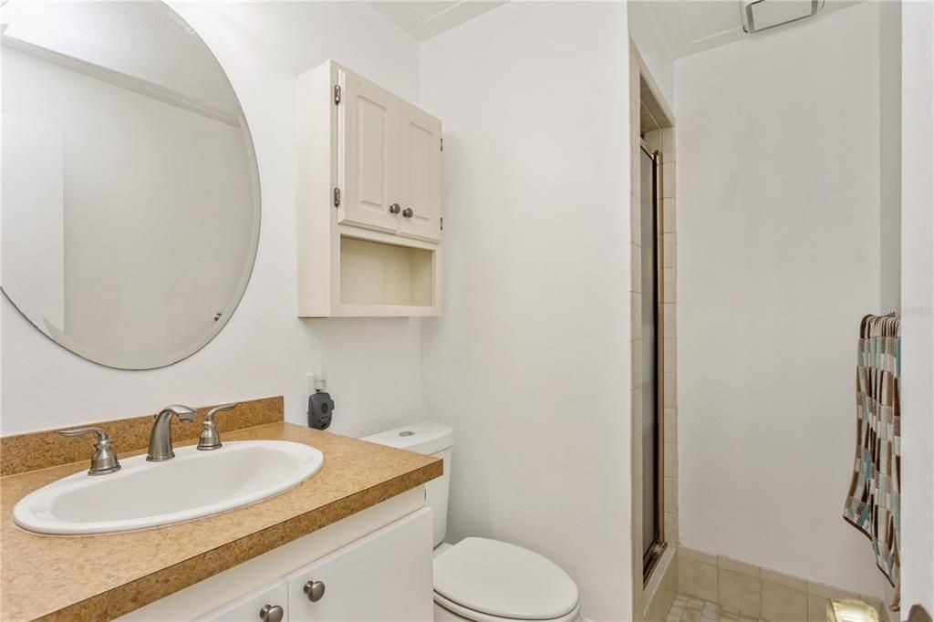 Master suite bathroom has walk in tile shower.