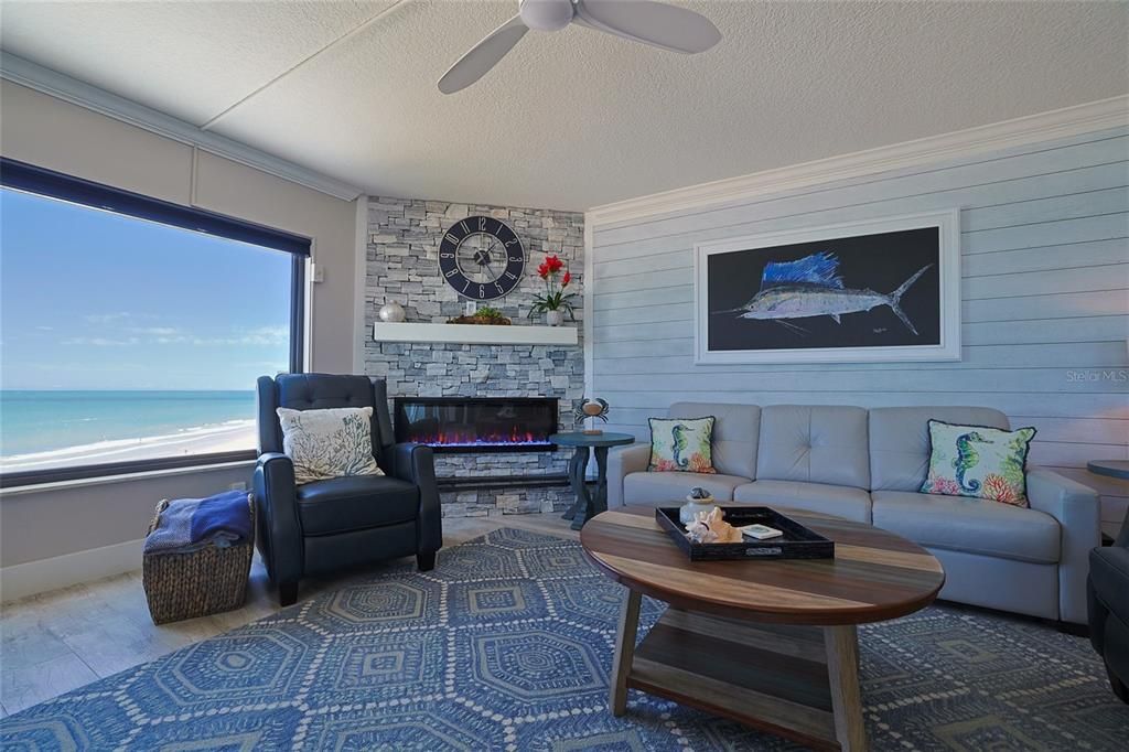 Massive picture window looking out over the sea, stone and shiplap accent walls, electic fireplace...set the mood.