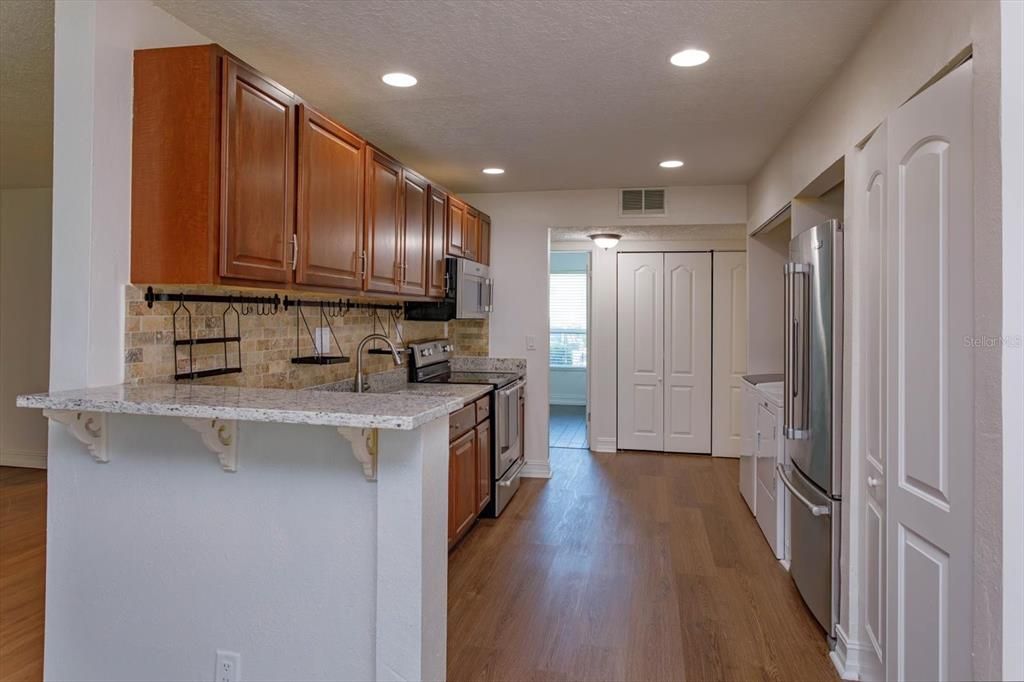 kitchen with wood cabinets, large panty, stainless steel appliances and washer and dryer