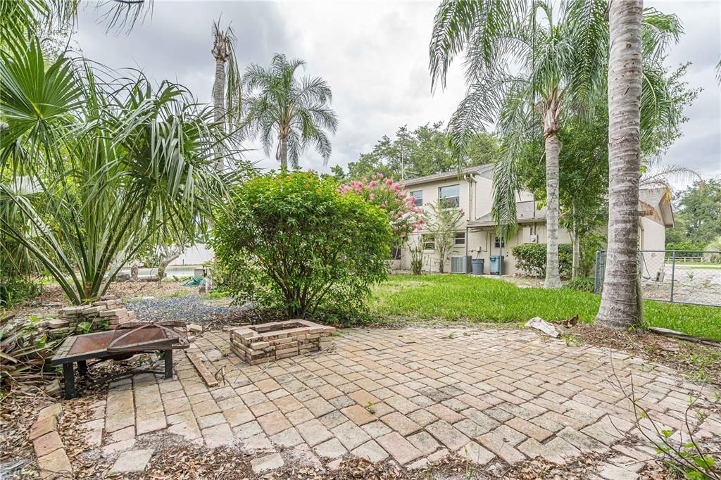 Backyard paver area perfect for a firepit or hammock.