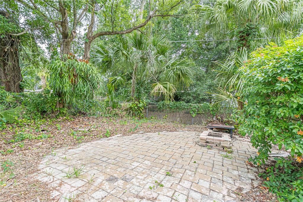 Backyard paver area perfect for a firepit or hammock.