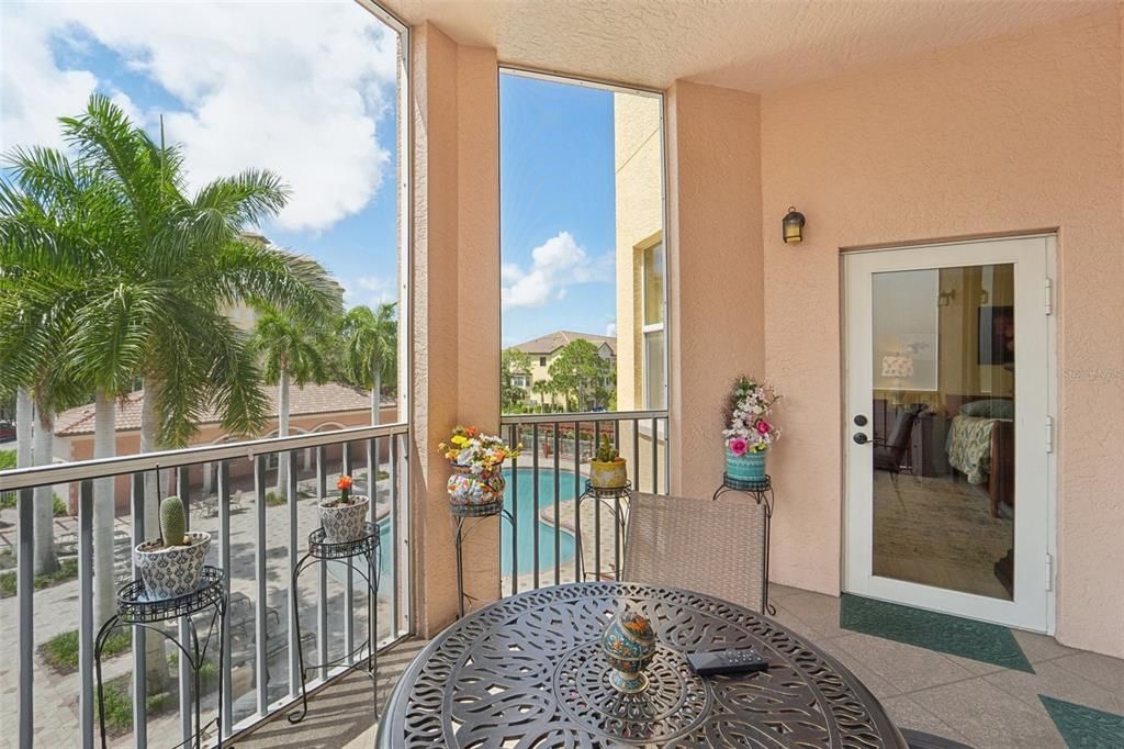 Door leads to Master Suite. Balcony with view of the pool through the Palm Trees for privacy