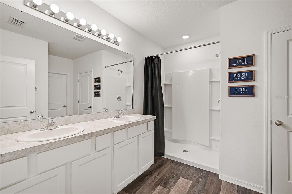 Primary bathroom w/ 2 sinks and walk in shower.