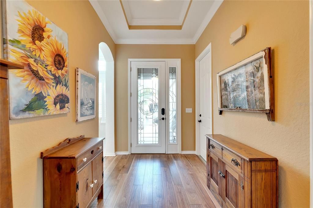 foyer has tray ceiling, door to 1 garage and entry to kitchen