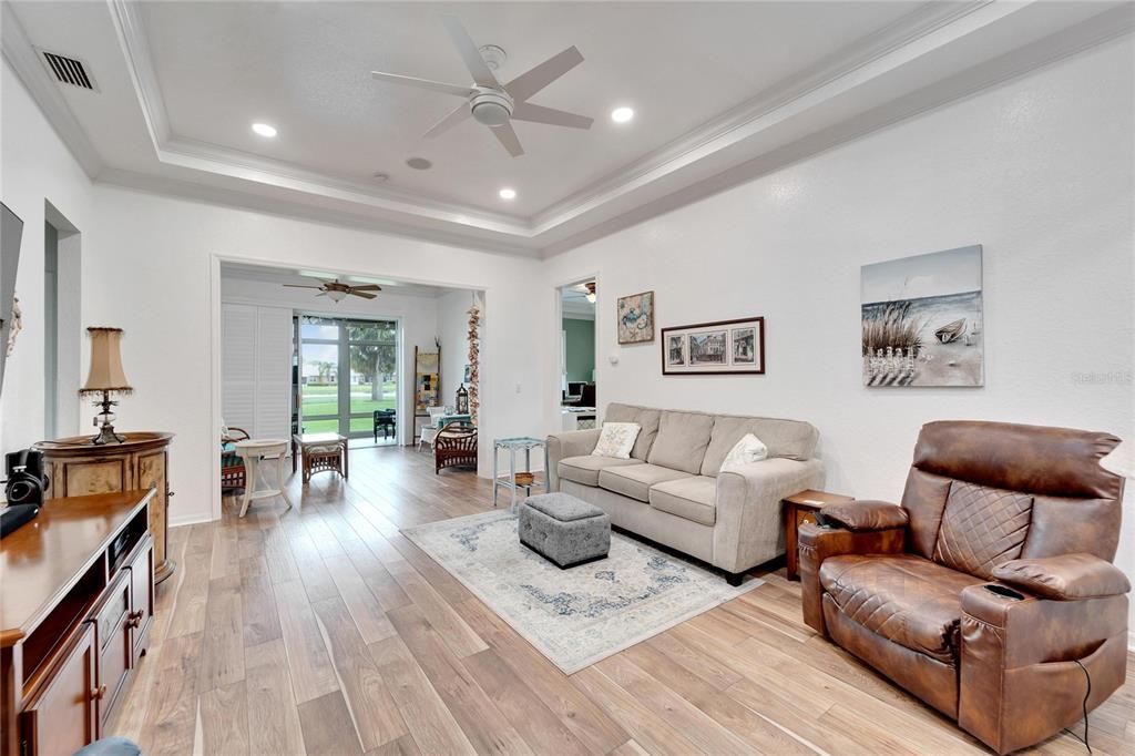 view into living area with tray ceiling and beautiful floors