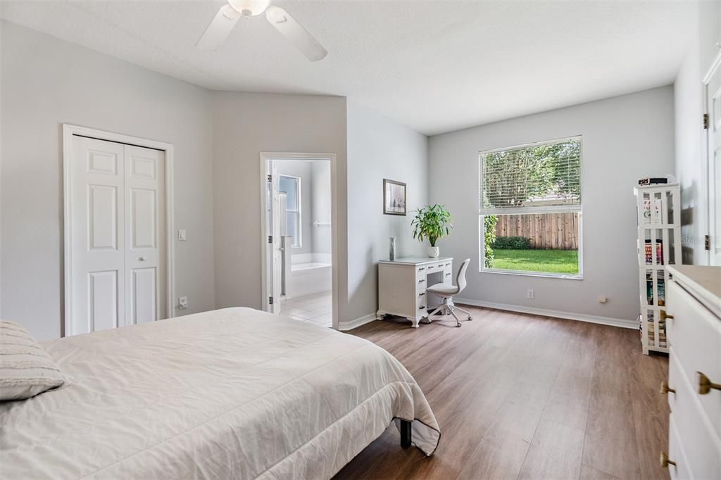 Master Bedroom, New Luxury Vinyl Flooring, Fan with light fixture and a walk in closet.