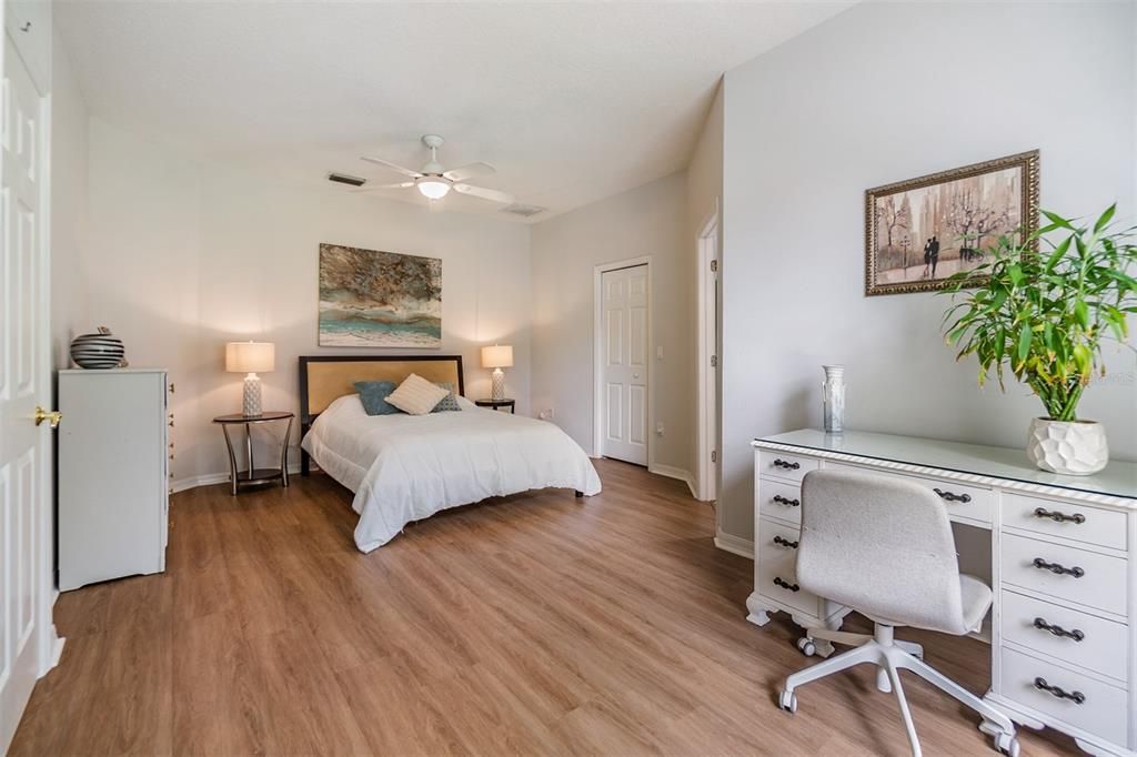 Master Bedroom, New Luxury Vinyl Plank Flooring, Fan with light fixture and a walk in closet.