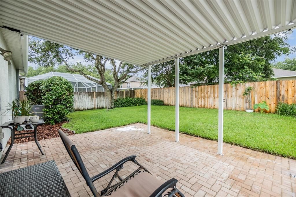 Nice back yard with covered area with pavers and fenced in.