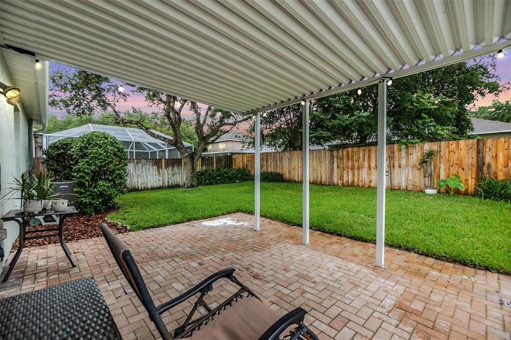 Nice back yard with covered area with pavers and fenced in.