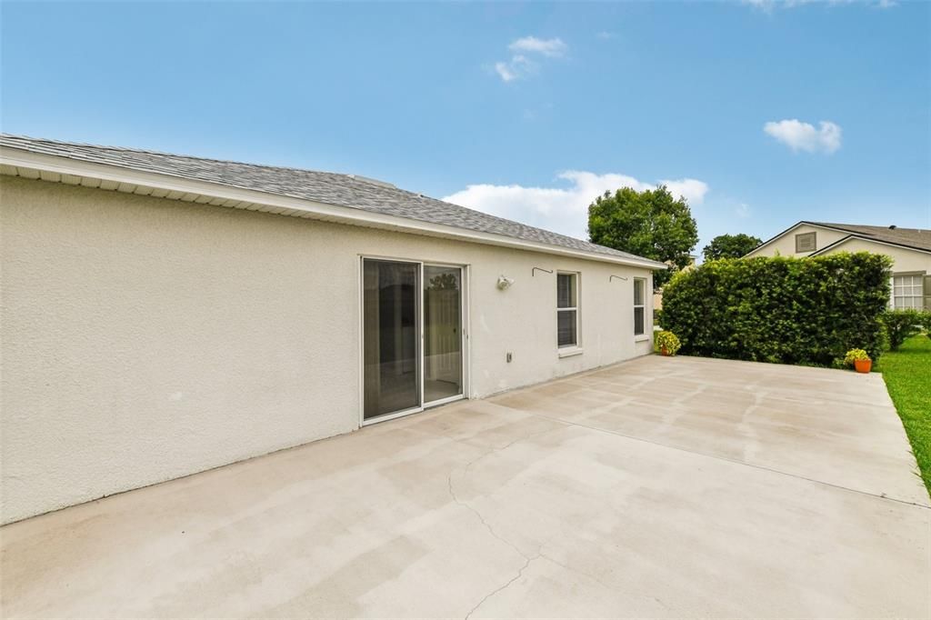 The back patio runs the length of the home and is surrounded by lush grass and manicured privacy hedges for the perfect canvas to create the outdoor space of your dreams!