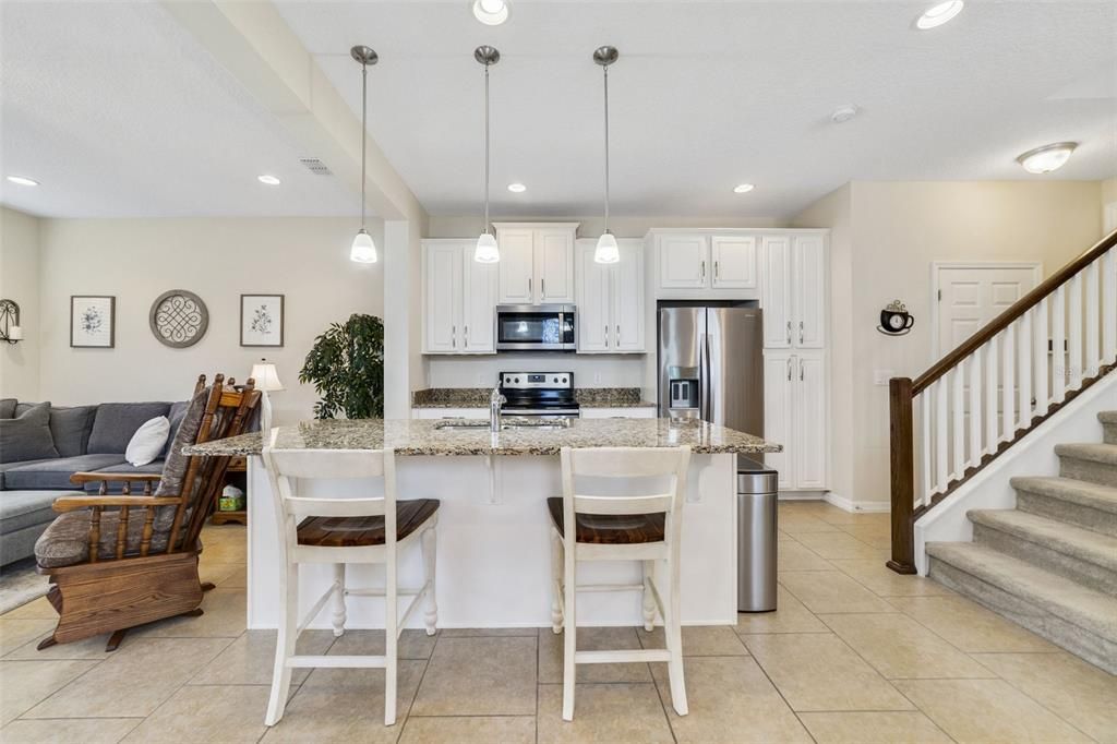The kitchen serves as the heart of it all where the home chef will be delighted to find STAINLESS STEEL APPLIANCES, plenty of cabinets storage, GRANITE COUNTERS and pendant lighting over the large ISLAND illuminates the casual bar seating.
