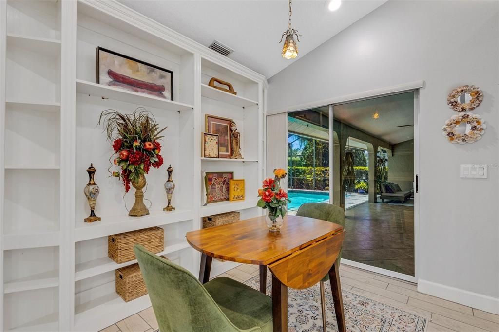 The cozy breakfast nook or casual dining space opens directly to the screen enclosed pool and lanai