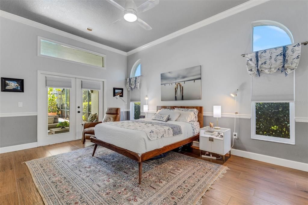 The "primary" bedroom boasts high ceilings, french doors with transom windows over that open directly to the covered lanai