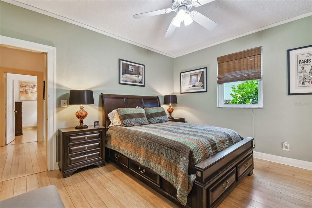 Primary bedroom with crown molding and bamboo floors