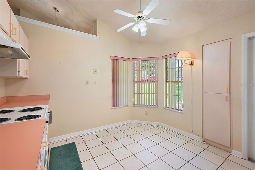 Kitchen with tile floors, vaulted ceiling, and eating nook