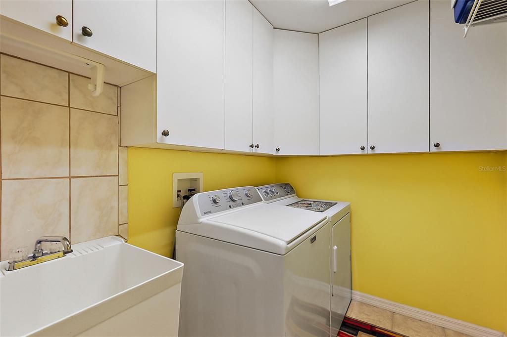 Inside laundry with loads of upper cabinets and a utility sink