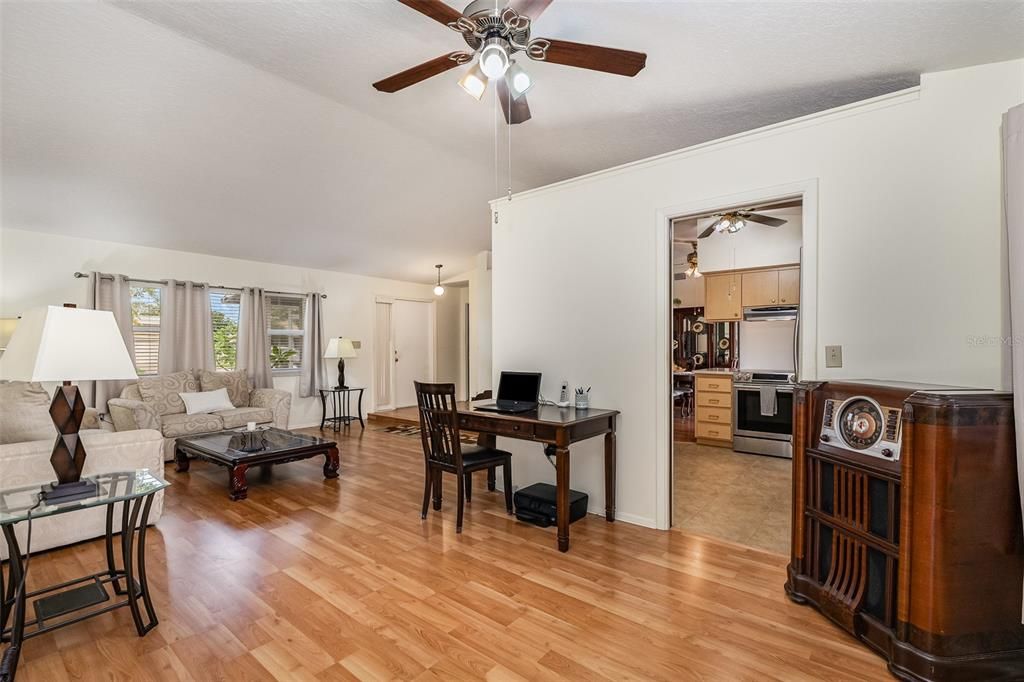 View of the living room and entry into kitchen standing by the primary bedroom.