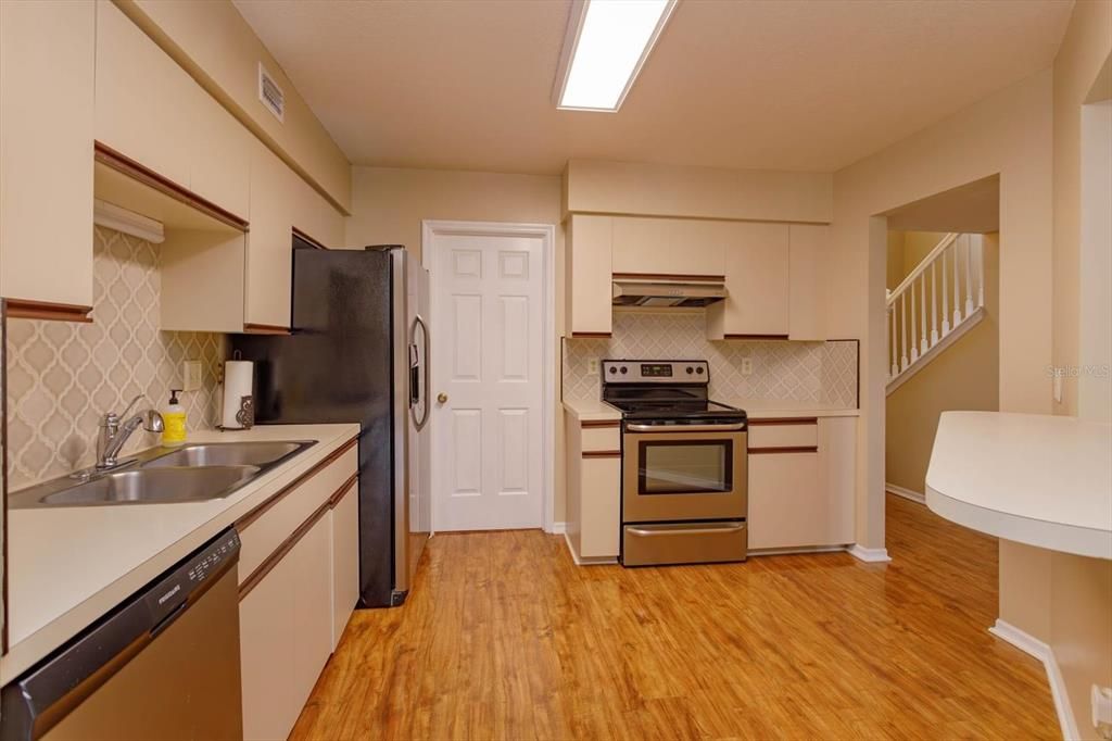 12' x 11' kitchen with breakfast bar, stainless appliances and tile backsplash