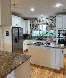 Open Kitchen with Island. Walk-in Pantry.  Door to back patio.