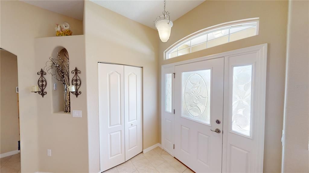 Well-lit inside foyer featuring a convenient coat closet.