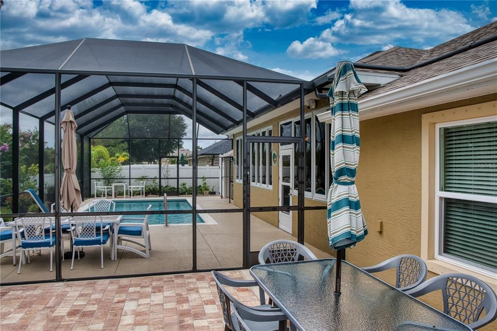 Open patio made from beautiful pavers, in addition to the caged pool area and Florida room, perfect for enjoying the open sunshine. Great for BBQs, sunning, and outdoor activities.