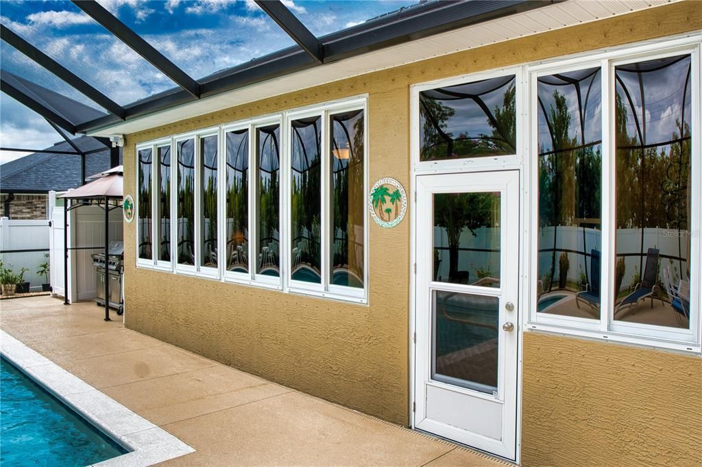 Exterior view of the Florida room showcases impressive, tinted windows, enhancing both style and energy efficiency.
