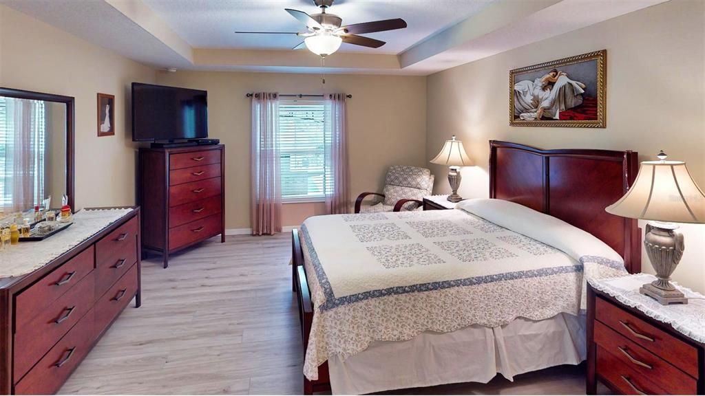 The master suite is a luxurious retreat, boasting a sophisticated tray ceiling, elegant laminate wood flooring, and ample space for relaxation and comfort. Its expansive layout provides the perfect sanctuary for unwinding after a long day.