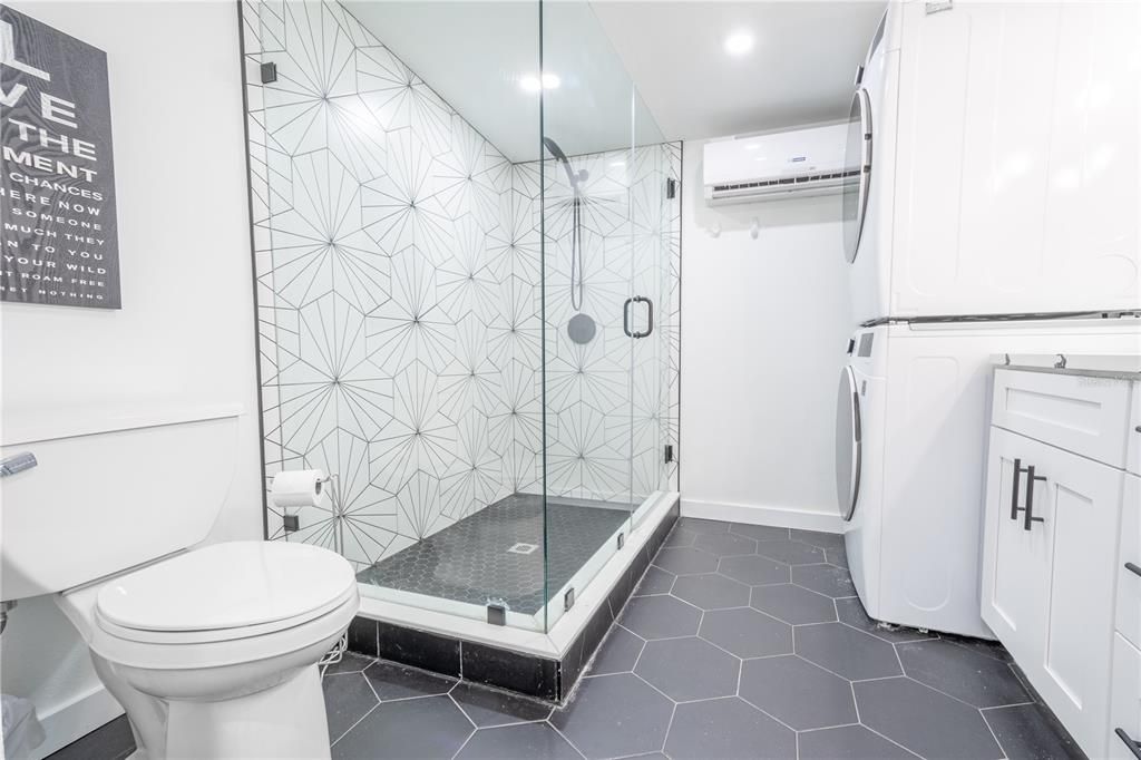 The primary bath features dark, rich ceramic tile flooring.