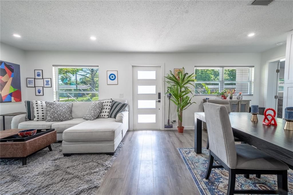 The open floor plan and spacious living area features abundant natural light, a neutral color palette, and recessed lighting.