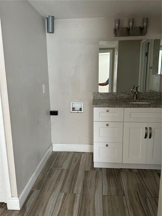 Bathroom Vanity next to Washer and Dryer Hookup. All tile