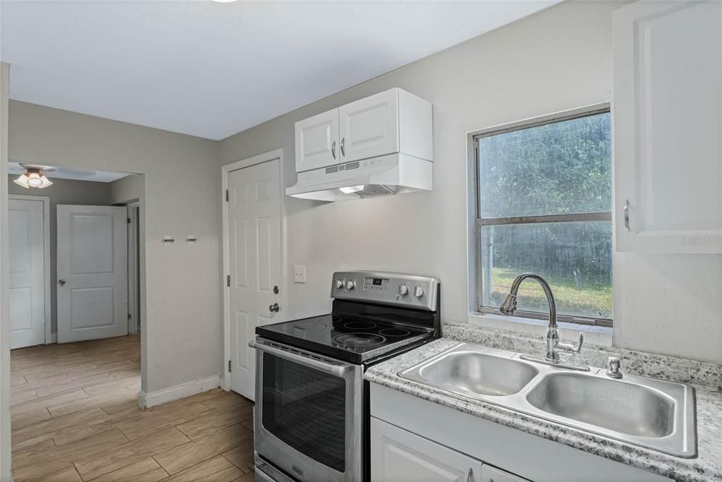 Kitchen showing exit to backyard and dinette in background