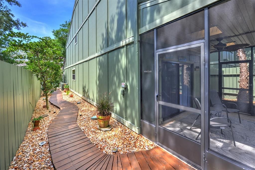 Wooden walkway leads you to the screened in porch off living room.