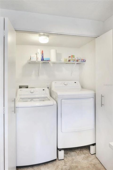 Laundry room located downstairs in kitchen area.