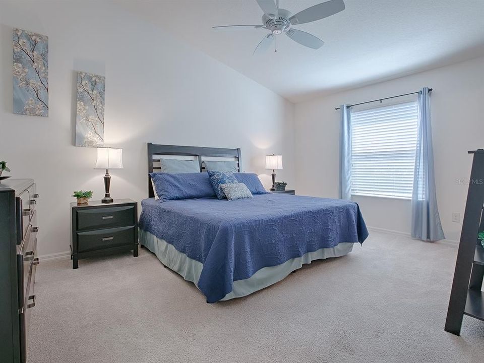 SPACIOUS PRIMARY BEDROOM WITH VAULTED CEILING, CEILING FAN, AND AN EN-SUITE BATH