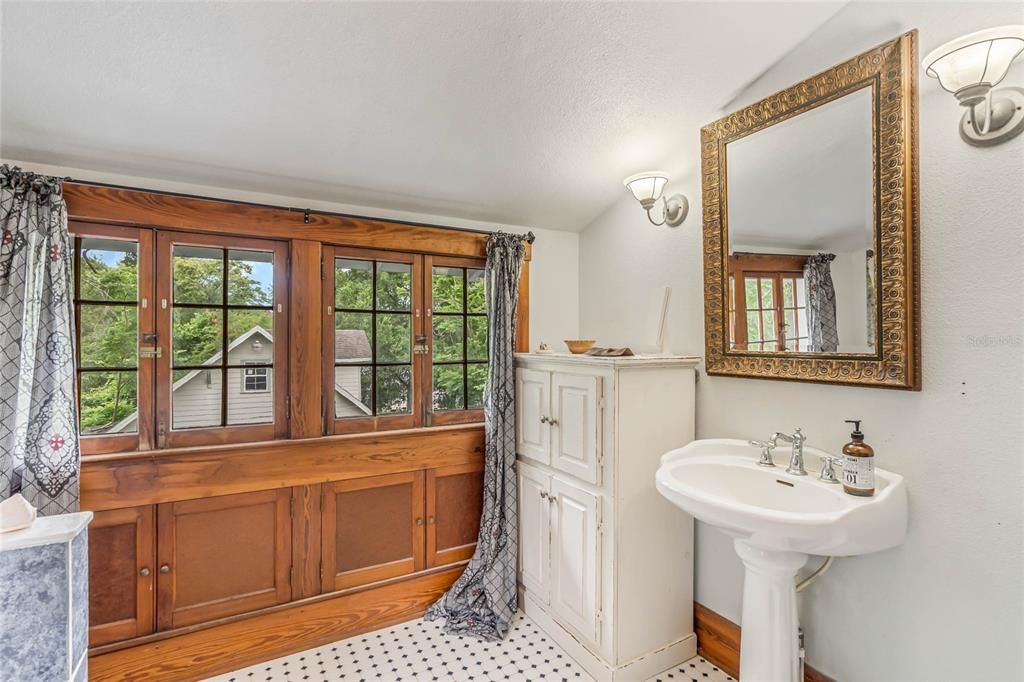 Second floor sun room with original built in under window storage.